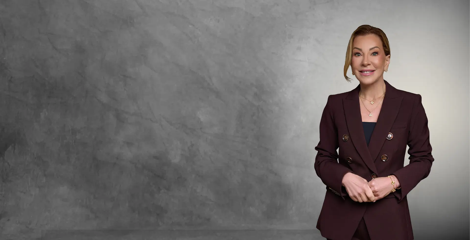Stephanie I. Byerly, MD, in a burgundy suit against a textured grey studio wall